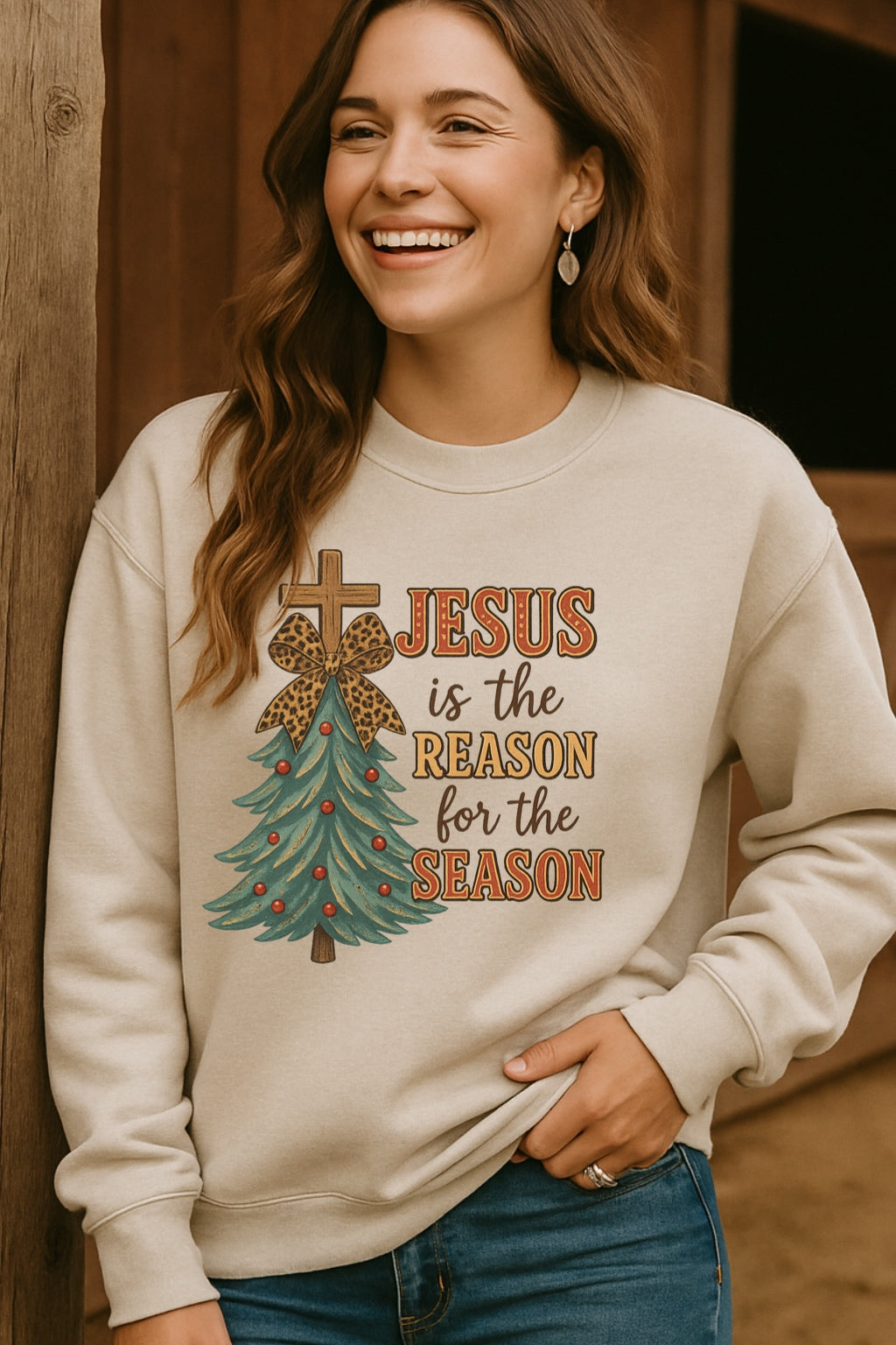 Woman wearing a beige sweatshirt with a Christmas design and text, standing against a wooden wall.